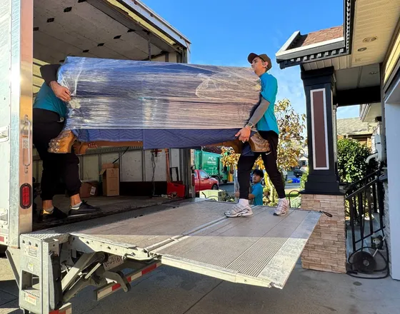 Movers loading boxes and furniture into a moving truck