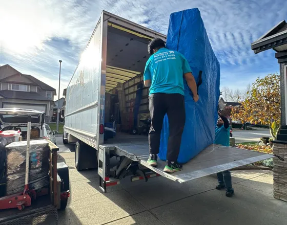A mover using a truck liftgate to load a large item