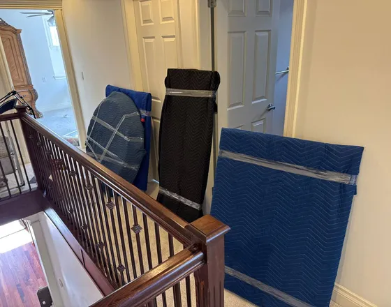 Wrapped furniture staged in a hallway during a move